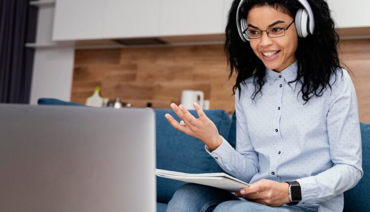 Adolescente sorridente com fones de ouvido e laptop durante escola online