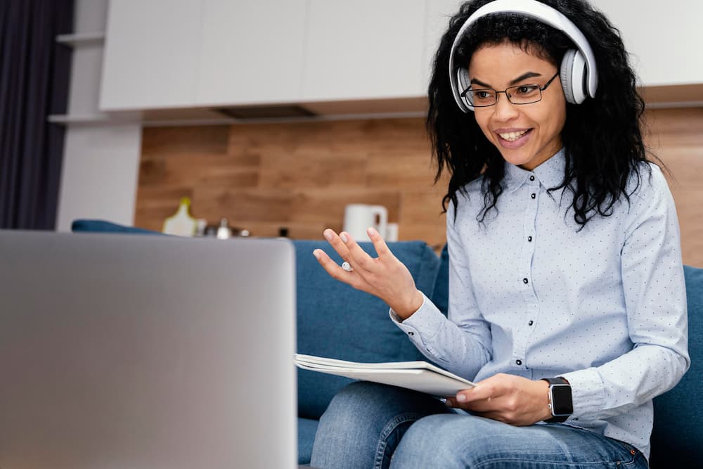 Adolescente sorridente com fones de ouvido e laptop durante escola online